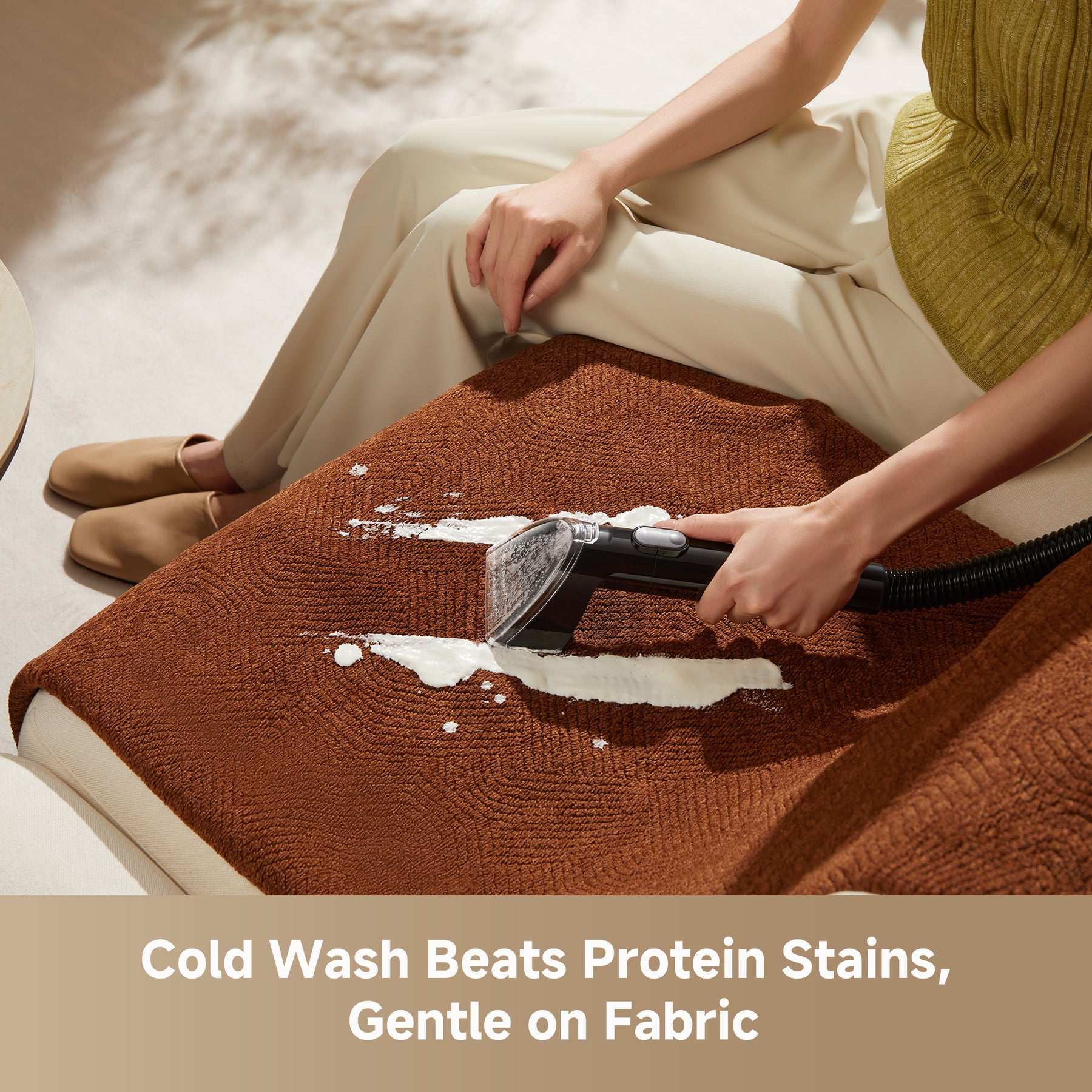 Steam spot cleaner nozzle cleaning a brown upholstered cushion with visible foam