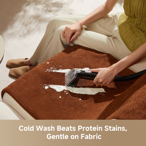 Steam spot cleaner nozzle cleaning a brown upholstered cushion with visible foam